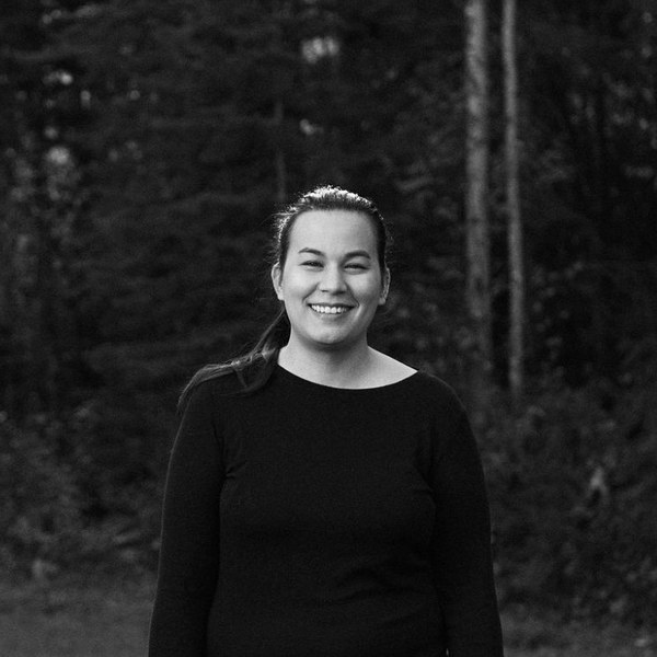 Black-and-white portrait of Lauren Yee smiling in a forest clearing
